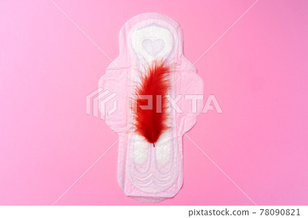 Open female hygienic pad with red feather top view 78090821