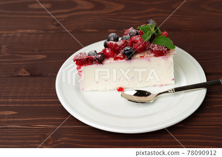 Piece of berry cheesecake served on brown wooden table 78090912