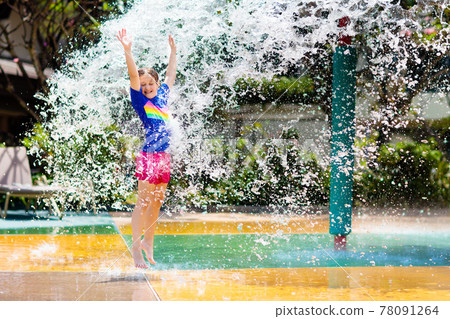 Child playing under tip bucket in water park. Child playing under tip bucket in water park. 78091264