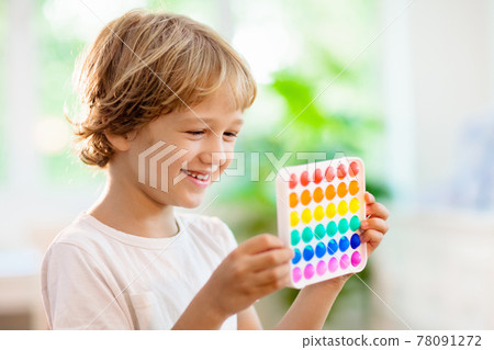 Kids with pop it sensory toy. Stress relief. Kids with pop it sensory toy. Stress relief. 78091272