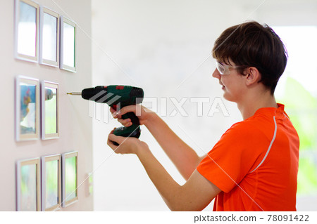 Man drilling wall. Home renovation and decoration. Man drilling wall. Home renovation and decoration. 78091422