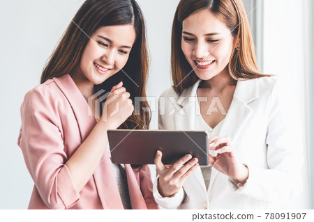Businesswomen using tablet computer in office. Businesswomen using tablet computer in office. 78091907