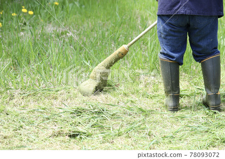 一位中年婦女用家用電動割草機割花園的腳 78093072