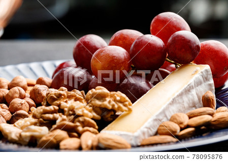 Close up of nuts and grapes on plate Close up of nuts and grapes on plate 78095876