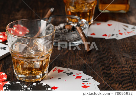 Playing poker with whiskey and cigars on table 78095952