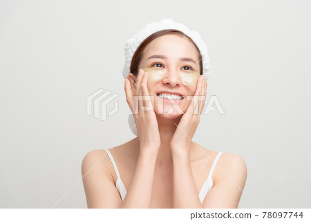 Close-up of a young woman with patches under eyes from wrinkles and dark circles. Isolated on white background 78097744