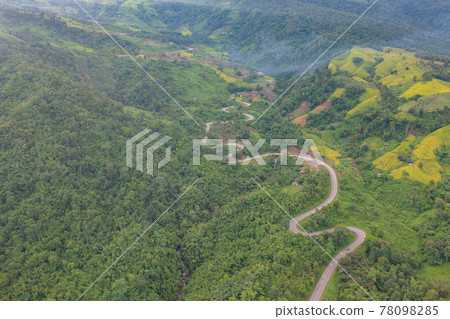 Aerial view of cars driving on curved, zigzag curve road or street on mountain hill with green natural forest trees in rural area of Phu Tub Berk, Phetchabun, Thailand. Aerial view of cars driving on curved, zigzag curve road or street on mountain hill with green natural forest trees in rural area of Phu Tub Berk, Phetchabun, Thailand. 78098285