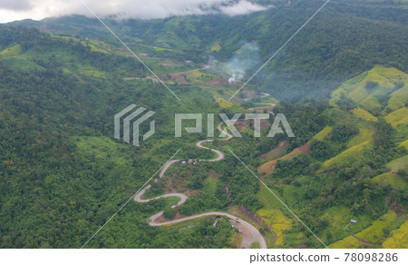 Aerial view of cars driving on curved, zigzag curve road or street on mountain hill with green natural forest trees in rural area of Phu Tub Berk, Phetchabun, Thailand. Aerial view of cars driving on curved, zigzag curve road or street on mountain hill with green natural forest trees in rural area of Phu Tub Berk, Phetchabun, Thailand. 78098286