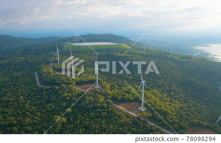 Aerial top view of wind turbines or windmills farm field with water in lake or river in industry factory. Power, sustainable green clean energy, and environment concept. Nature innovation. 78098294