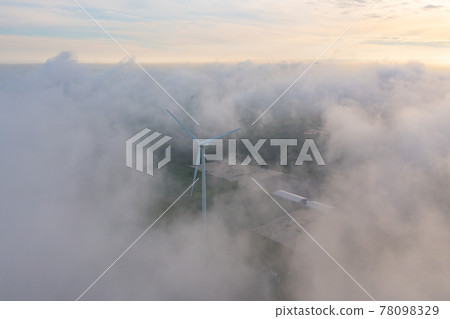 Aerial view of wind turbines or windmills farm field in industry factory with sea fog. Power, sustainable green clean energy, and environment concept. Nature innovation. Aerial view of wind turbines or windmills farm field in industry factory with sea fog. Power, sustainable green clean energy, and environment concept. Nature innovation. 78098329