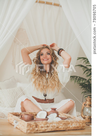 Happy woman resting in white hotel room at a tropical resort 78098705