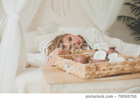 Relaxing woman resting in white hotel room at a tropical resort 78098708