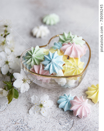 Small colorful meringues in the  heart shaped bowl 78099245