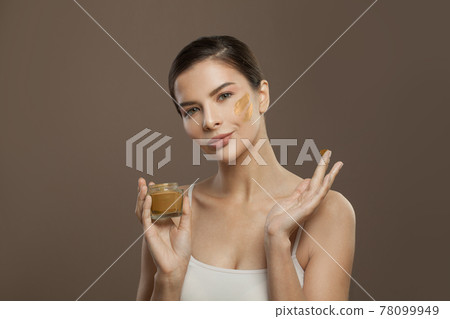 Healthy woman spa model applying organic cream to her skin. Facial treatment and skin care concept Healthy woman spa model applying organic cream to her skin. Facial treatment and skin care concept 78099949