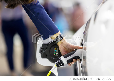 Hand holding Electric car charger.  78100999