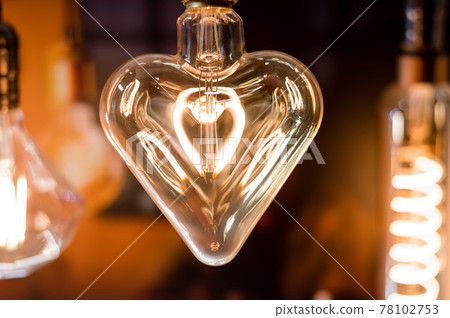 Many differently shaped incandescent bulbs are suspended in the dark Many differently shaped incandescent bulbs are suspended in the dark 78102753