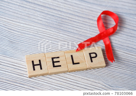 Red ribbon with the word help. Concept of AIDS, HIV symbol. 78103066