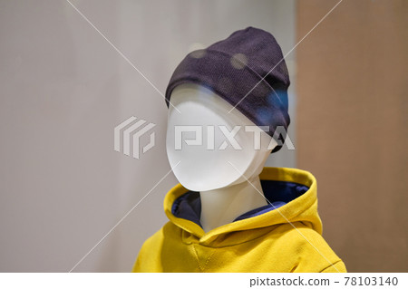 Bust of a baby mannequin in a hat and a yellow jumper. 78103140