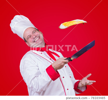 cook throw a fried egg on a frying pan 78103485