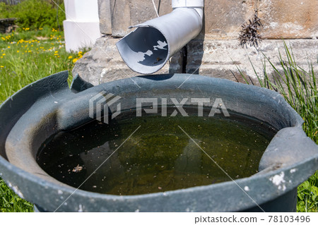 A full tank of rainwater under the gutter, close up. A full tank of rainwater under the gutter, close up. 78103496