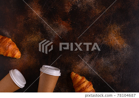 Coffee to go in a paper cup with croissants. Coffee to go in a paper cup with croissants. 78104687