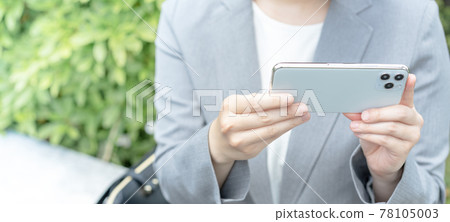 Watching videos on your smartphone in the park Banner size at hand of a young woman 78105003