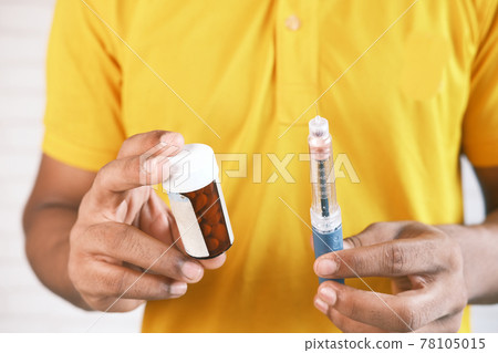 hand holding Insulin pens and pill container hand holding Insulin pens and pill container 78105015