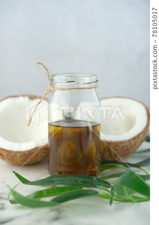 slice of fresh coconut and bottle of oil on a table slice of fresh coconut and bottle of oil on a table 78105017