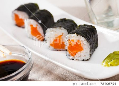 Maki rolls with salmon served with wasabi and soy sauce on white plate 78106754