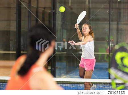 Young beautiful woman with racket playing padel Young beautiful woman with racket playing padel 78107185