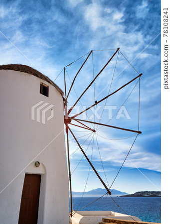 Famous tourist attraction of Mykonos, Greece. Traditional whitewashed windmill by sea. Summer, blue sky. Travel destination, iconic view. Rear upshot 78108241