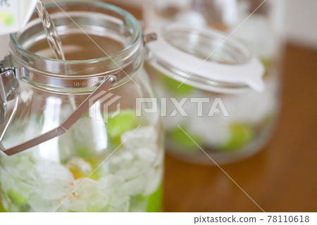 Making plum wine | Pour white liquor into a bottle container Making plum wine | Pour white liquor into a bottle container 78110618
