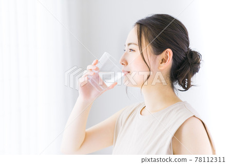 A young woman drinking mineral water A young woman drinking mineral water 78112311