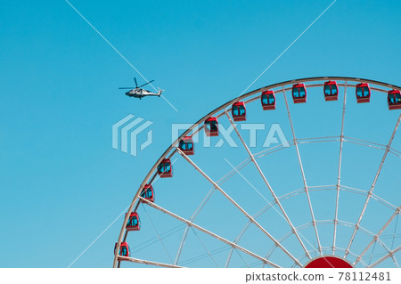 Detail of the Hong Kong observation wheel and Helicopter on blue sky 78112481