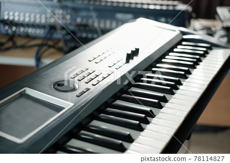 Electronic musical keyboard synthesizer close-up view. piano for recording music in a studio Electronic musical keyboard synthesizer close-up view. piano for recording music in a studio 78114827