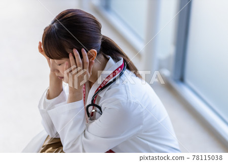 Female doctor crouching in the hospital Female doctor crouching in the hospital 78115038