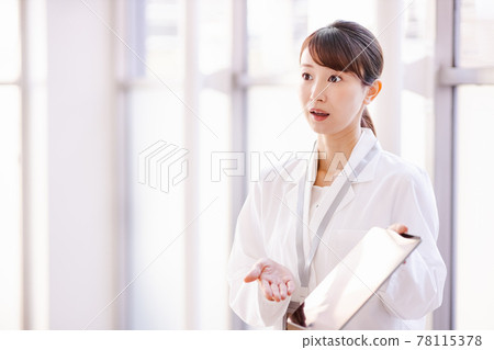 一名醫務工作者婦女向框架外的人展示平板電腦終端的屏幕 一名醫務工作者婦女向框架外的人展示平板電腦終端的屏幕 78115378