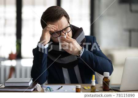 Sad sick office worker, businessman, manager wrapped in warm scarf Sad sick office worker, businessman, manager wrapped in warm scarf 78115890