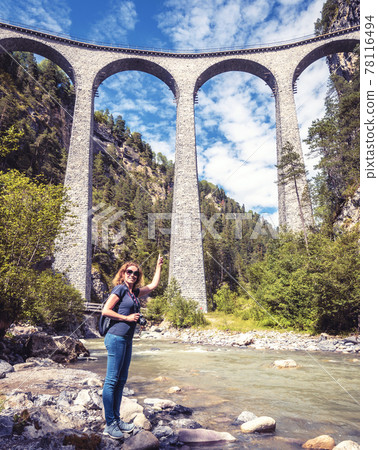 Young female tourist visits Landwasser Viaduct in Switzerland Young female tourist visits Landwasser Viaduct in Switzerland 78116494
