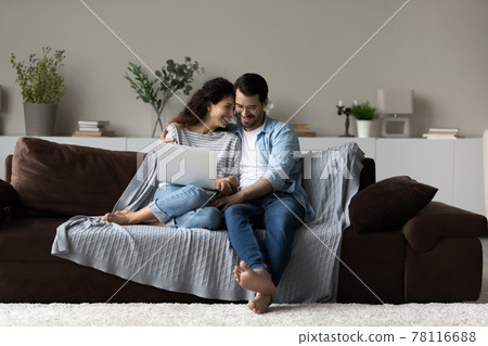 Happy multiracial couple relax at home with laptop Happy multiracial couple relax at home with laptop 78116688