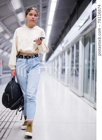 Portrait of a confident girl in the subway, holding a mobile phone Portrait of a confident girl in the subway, holding a mobile phone 78116874