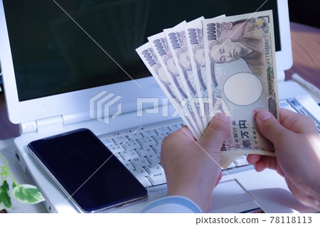 Woman with a computer and money 78118113