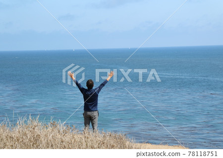 Behind a man who spreads his hands toward the sea and sky Behind a man who spreads his hands toward the sea and sky 78118751