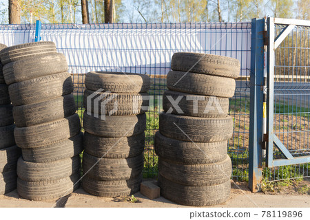 Tires. Car wheels are stacked in a column. Old tires at the service station. Tires. Car wheels are stacked in a column. Old tires at the service station. 78119896