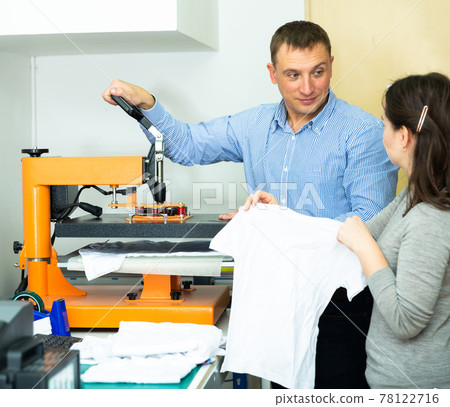 Man and woman printing t-shirt in a workshop Man and woman printing t-shirt in a workshop 78122716