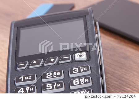 Payment terminal with credit card and mobile phone. Cashless paying for shopping. Finance concept Payment terminal with credit card and mobile phone. Cashless paying for shopping. Finance concept 78124204