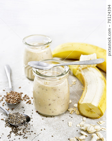 Milkshake with chia and banana in jars on stone table Milkshake with chia and banana in jars on stone table 78124394