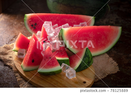 watermelon and watermelon pieces in a wooden background watermelon and watermelon pieces in a wooden background 78125889