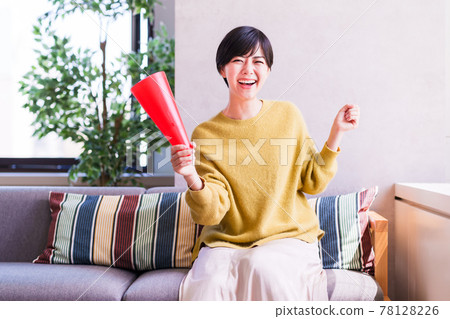 A young woman watching sports on TV [Corona Sorrow New Normal] 78128226