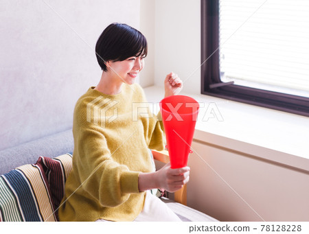 A young woman watching sports on TV [Corona Sorrow New Normal] 78128228